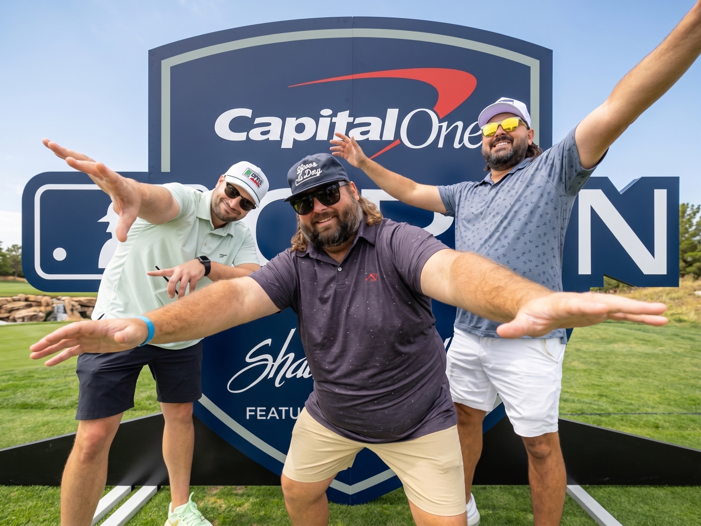 Players celebrating in front of the Capital One Open sign
